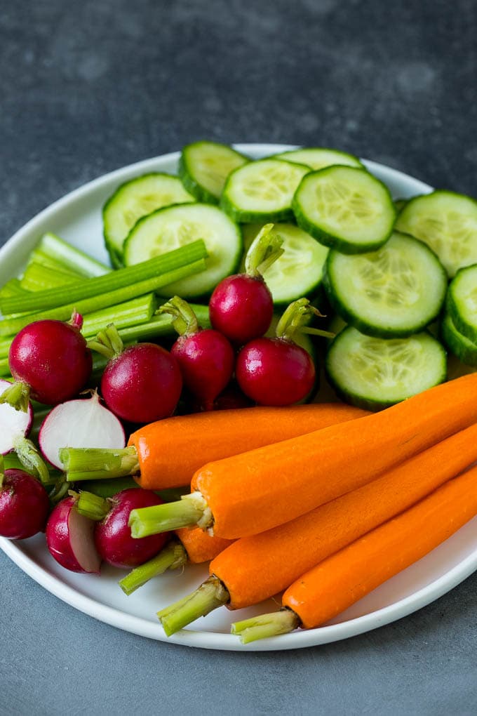 This homemade veggie tray is an assortment of colorful vegetables paired with a variety of flavorful dips. Carrots, celery, radishes and cucumber on a plate.