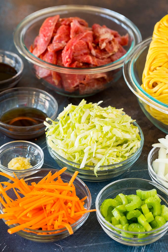 This beef lo mein is stir fried steak and vegetables tossed with egg noodles in a savory sauce. Bowls of ingredients including steak, carrots, celery, cabbage and noodles.