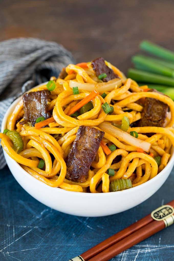 This beef lo mein is stir fried steak and vegetables tossed with egg noodles in a savory sauce. A bowl of beef lo mein topped with green onions.