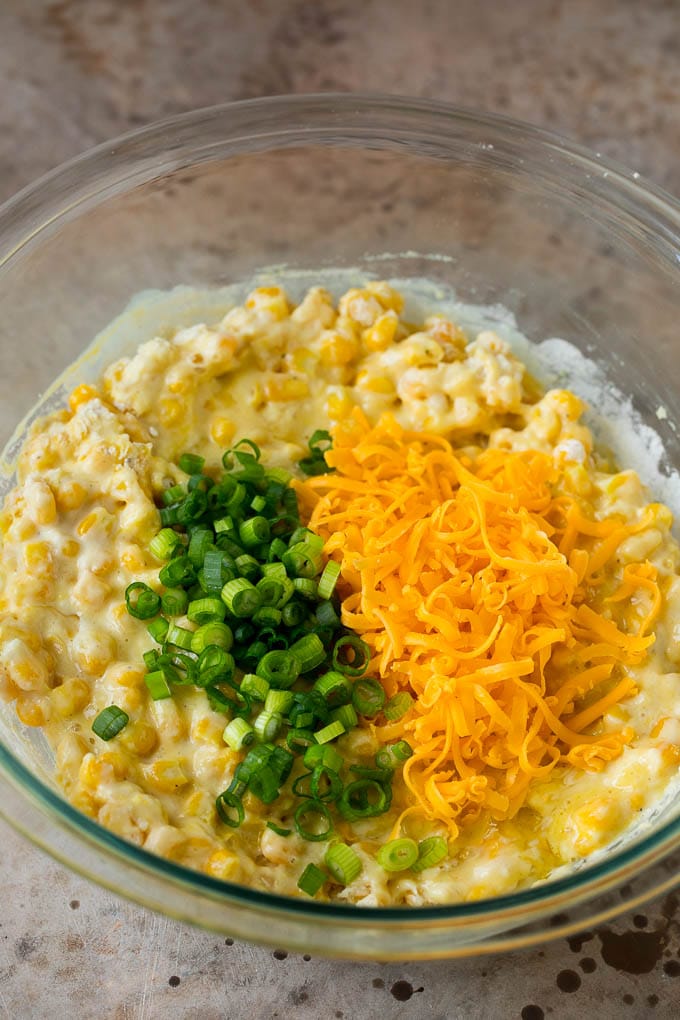 These crispy corn fritters are easy to make and are the perfect appetizer or lighter main course. #corn #sadud Corn batter topped with green onions and shredded cheese.
