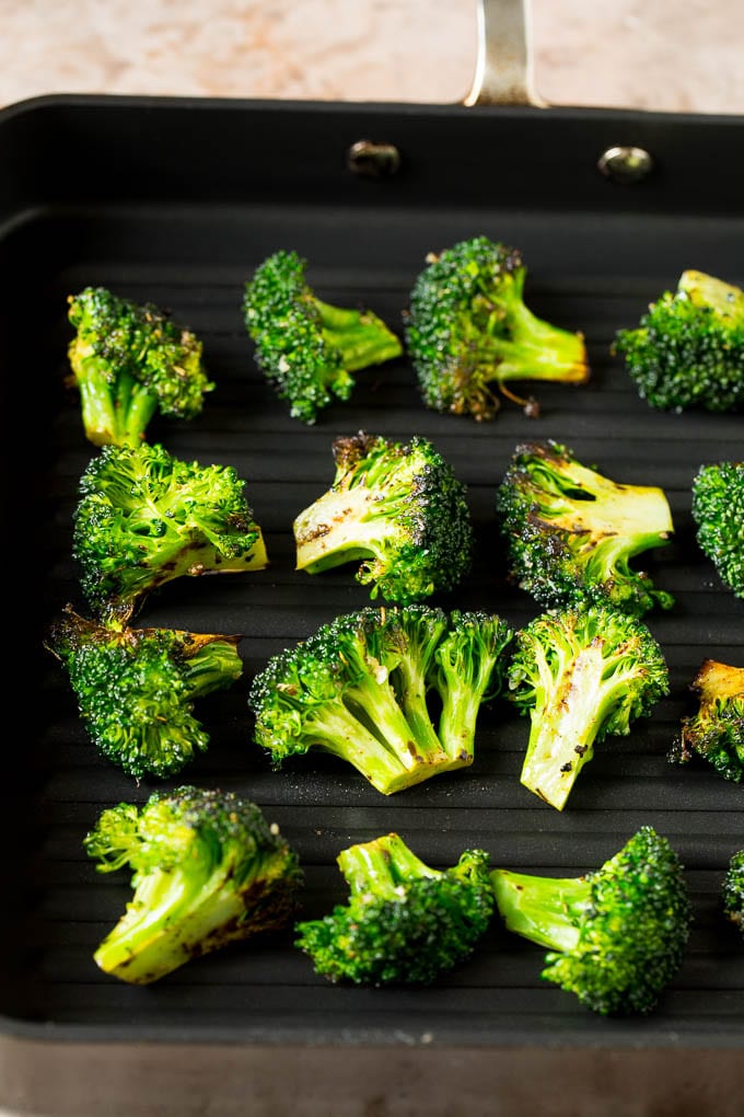 Grilled broccoli is packed with flavor and is a colorful and healthy side dish! #broccoli #sadud Broccoli florets on a grill pan.
