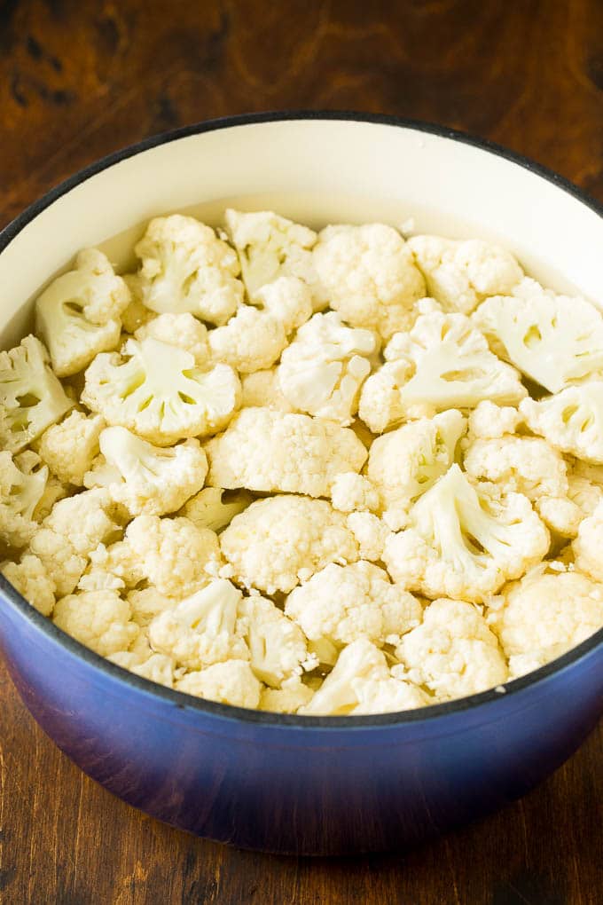 These cauliflower mashed potatoes are mixed with butter, cream and seasonings to make a super delicious side dish that's low in carbohydrates. Cauliflower florets in a pot of water.