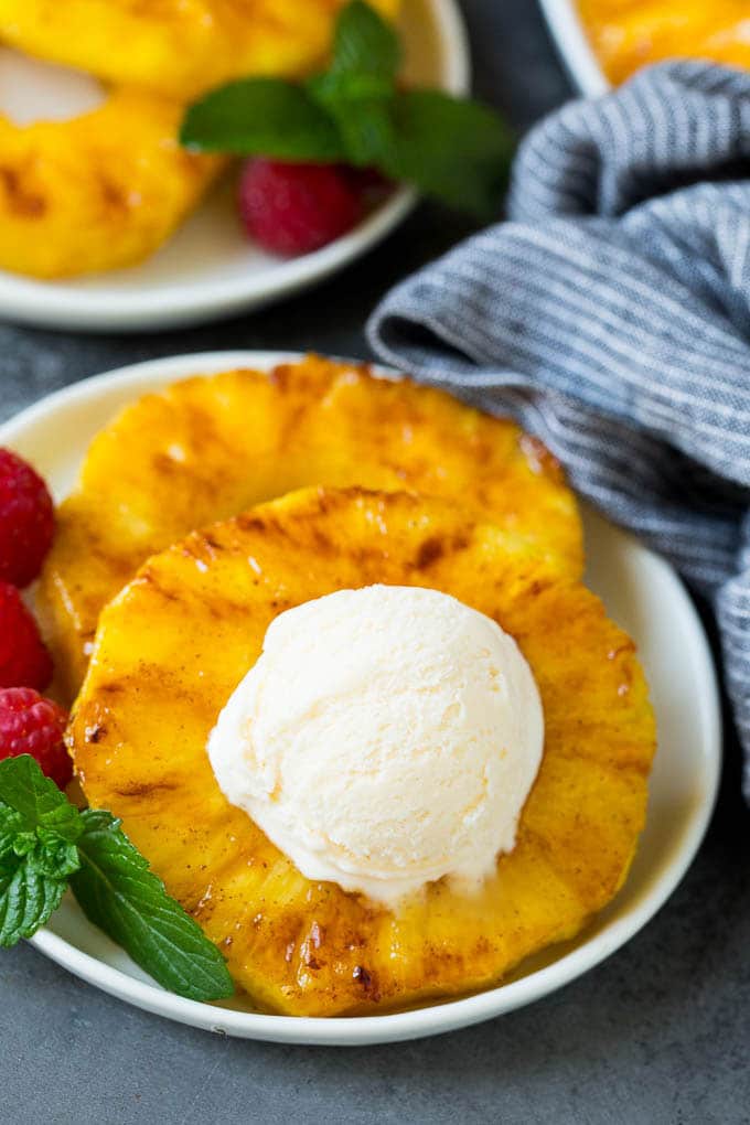 Brown sugar grilled pineapple is a quick and easy side dish or dessert! Grilled pineapple with a scoop of ice cream on top of it.