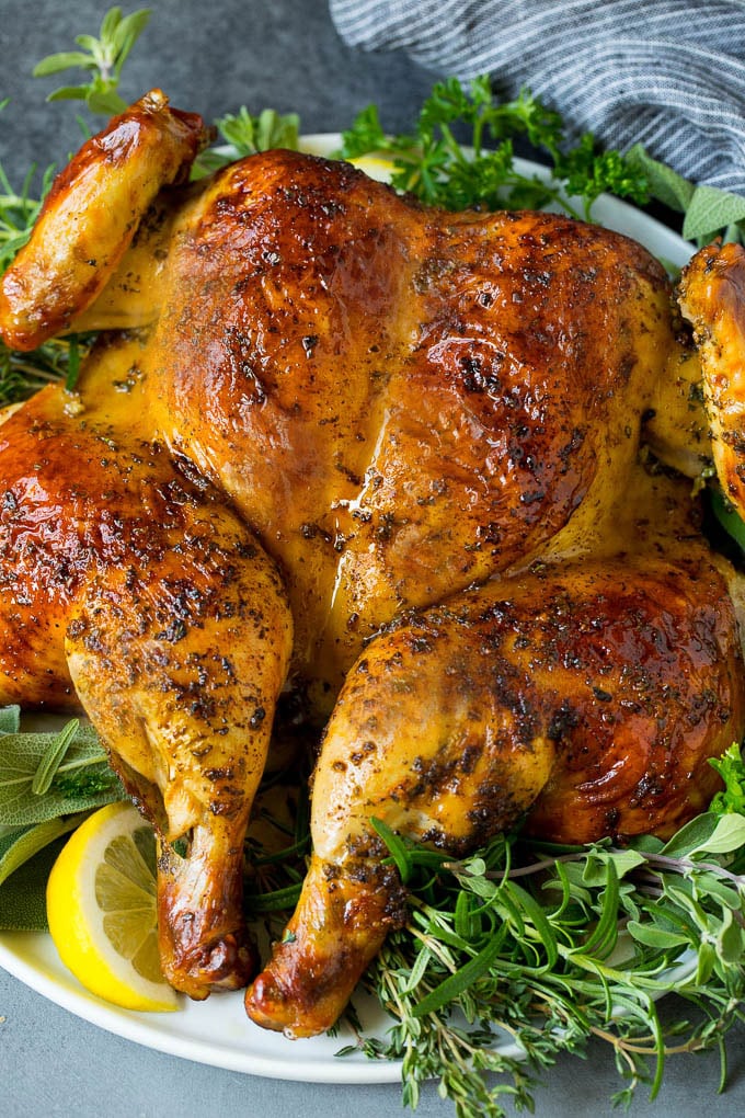 This spatchcock chicken is tender, juicy and cooks quickly, the perfect easy dinner! A spatchcock chicken on a bed of herbs and lemon.