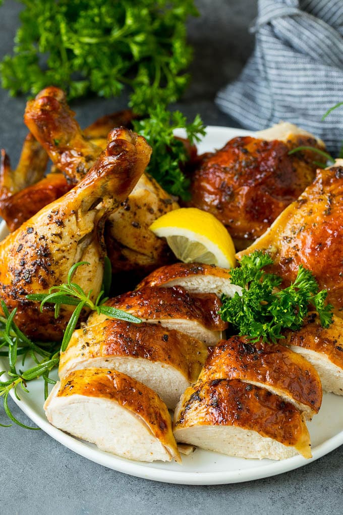 This spatchcock chicken is tender, juicy and cooks quickly, the perfect easy dinner! A carved spatchcock chicken on a serving plate.