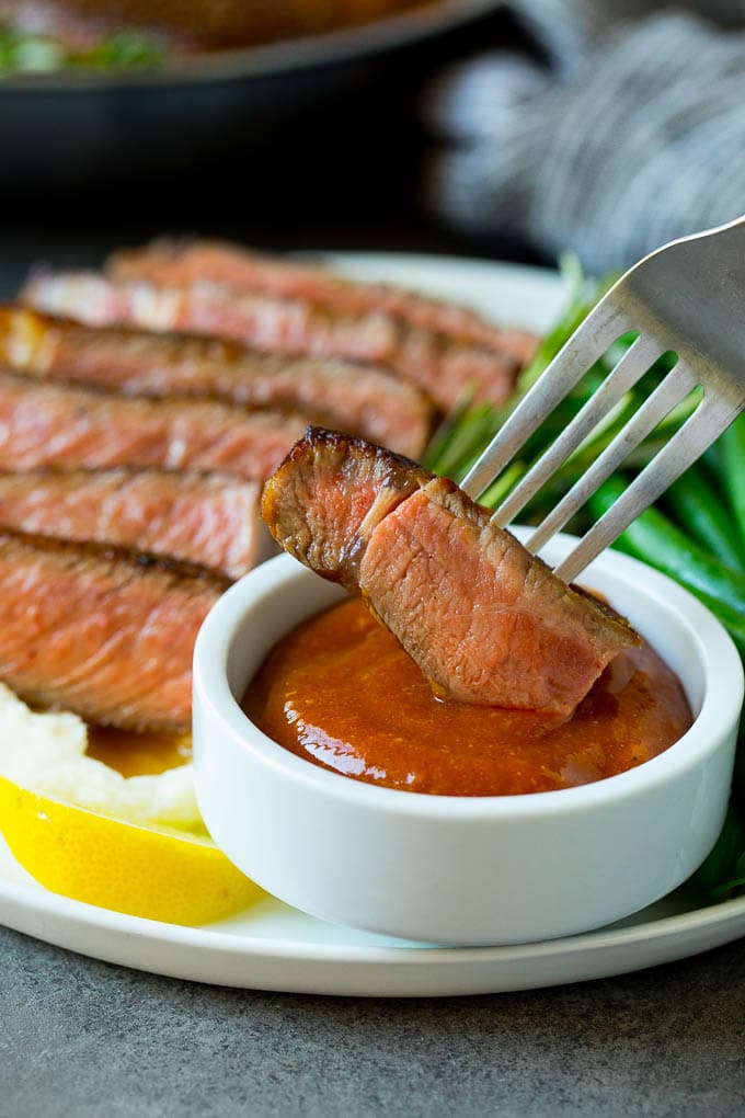 Homemade steak sauce is a savory blend that takes just 5 minutes to make and goes perfectly with beef, chicken and pork. A fork dipping a piece of meat into steak sauce.