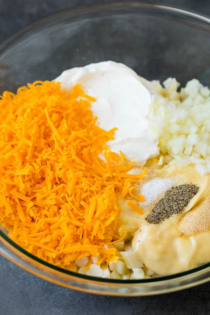 These cheesy potatoes are diced potatoes tossed in a creamy blend of sour cream, butter and cheese, then baked to golden brown perfection. Diced potatoes, cream soup, shredded cheese and spices in a bowl.