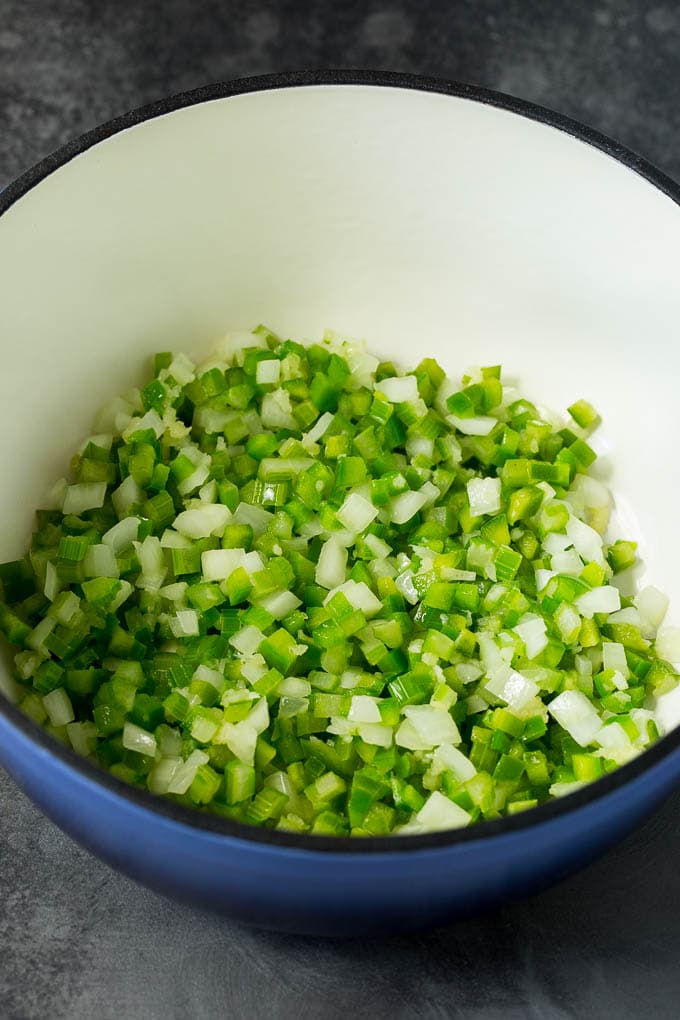 This Hoppin' John recipe is black eyed peas simmered with ham and vegetables until tender, then served over rice. Onions, celery and bell peppers cooked in a pot.