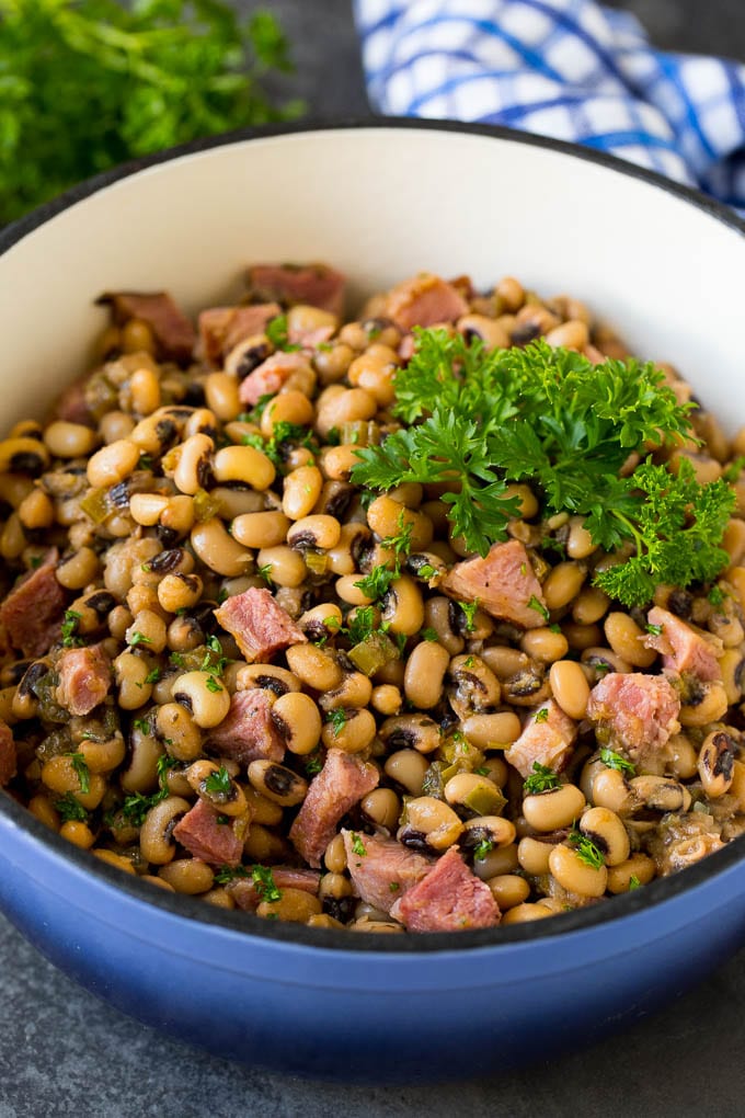 This Hoppin' John recipe is black eyed peas simmered with ham and vegetables until tender, then served over rice. A pot of Hoppin' John made with stewed black eyed peas, ham and vegetables.