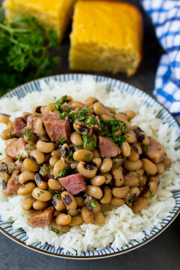 This Hoppin' John recipe is black eyed peas simmered with ham and vegetables until tender, then served over rice. Hoppin' John served over steamed rice and garnished with parsley.