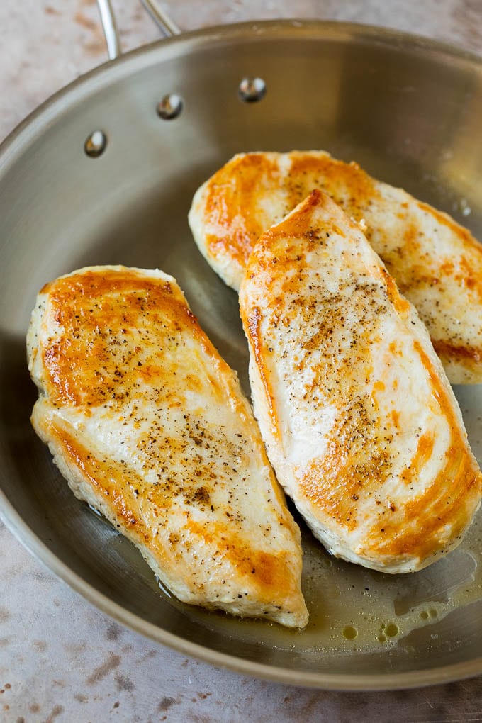 Seared chicken breasts in a pan.