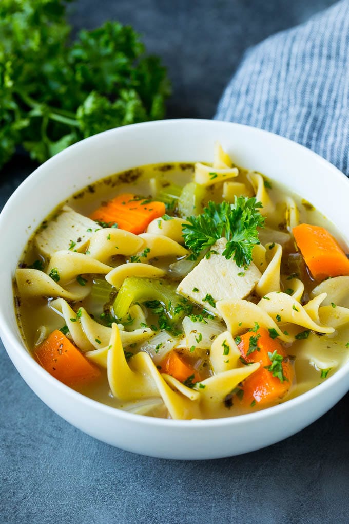 This turkey soup recipe is homemade turkey broth loaded with vegetables, diced turkey and egg noodles. A bowl of turkey soup garnished with fresh parsley.