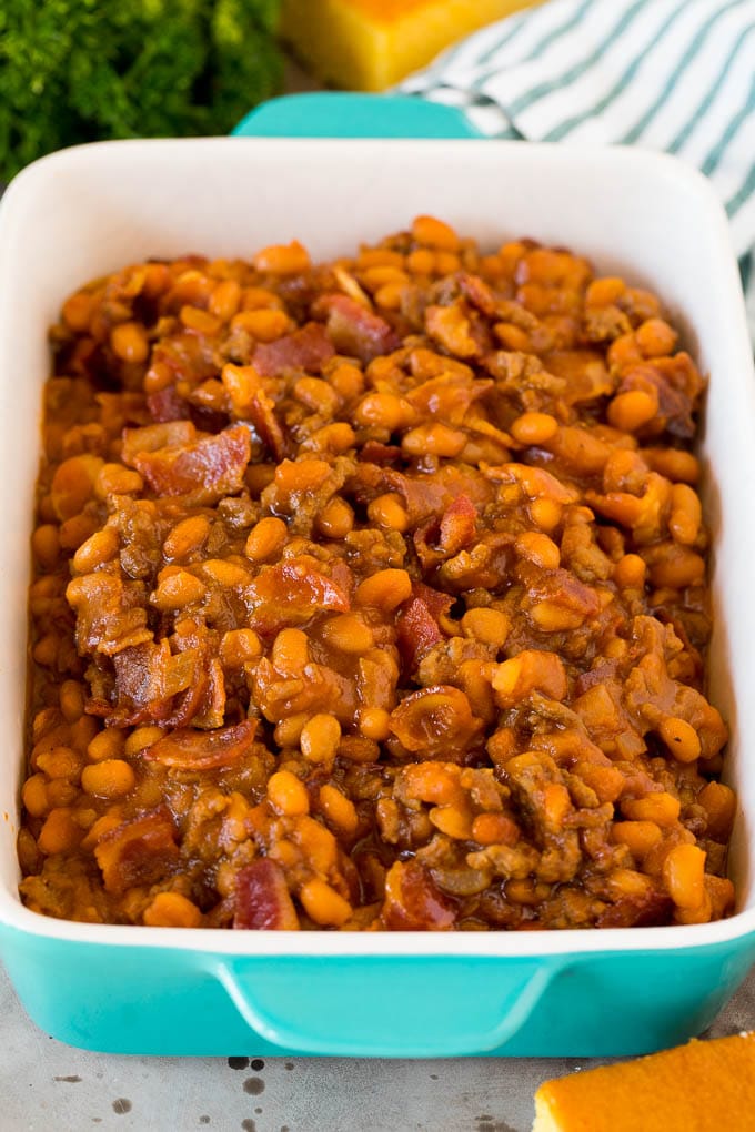 This cowboy beans recipe is made with ground beef and bacon, all baked together in a sweet and savory sauce. A serving dish of cowboy beans with bacon.