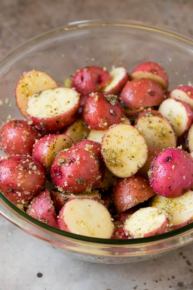 These oven roasted potatoes are baby potatoes coated in olive oil, garlic, herbs and parmesan cheese, then baked until golden brown and crispy. Cut potatoes tossed in olive oil and herbs.