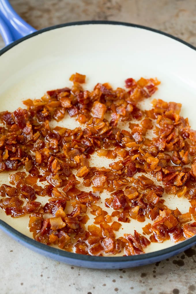 This succotash recipe is a combination of bacon, corn, tomatoes and lima beans, all cooked together to make a colorful and delicious side dish. Cooked bacon in a pan.