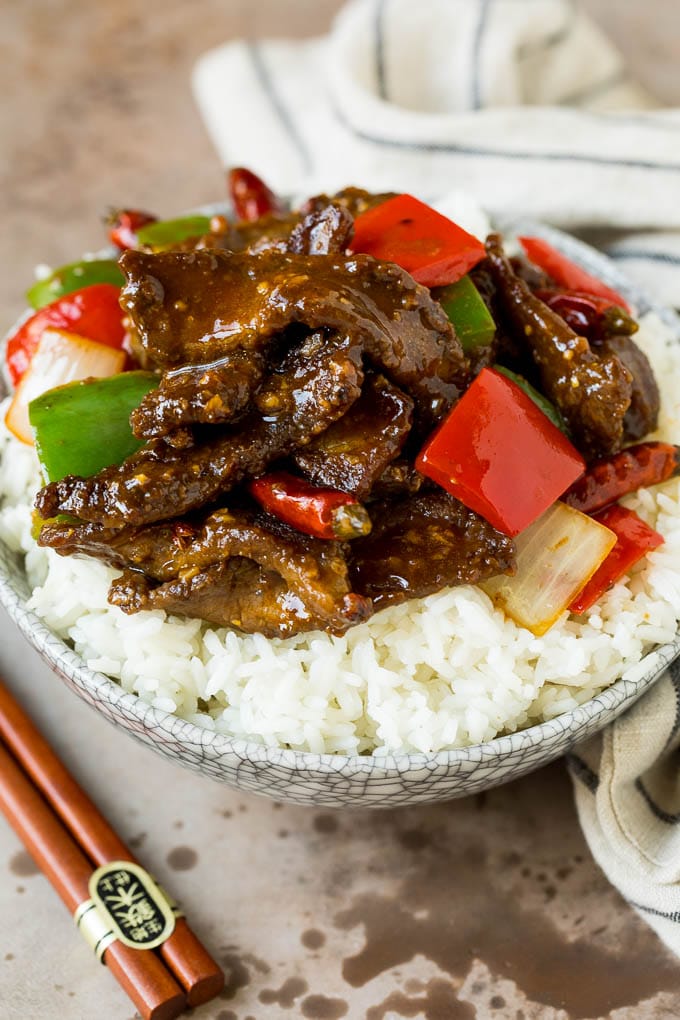 This Szechuan beef is a spicy stir fry made with tender pieces of beef and colorful vegetables, all tossed in a sweet and savory sauce. A bowl of Szechuan beef served over steamed rice.