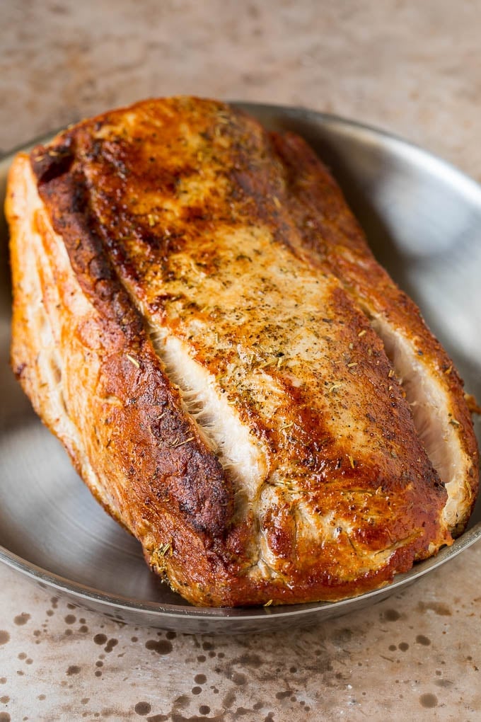 This crock pot pork roast is tender pork loin simmered in a slow cooker in a rich and flavorful gravy. A seared pork loin in a pan.