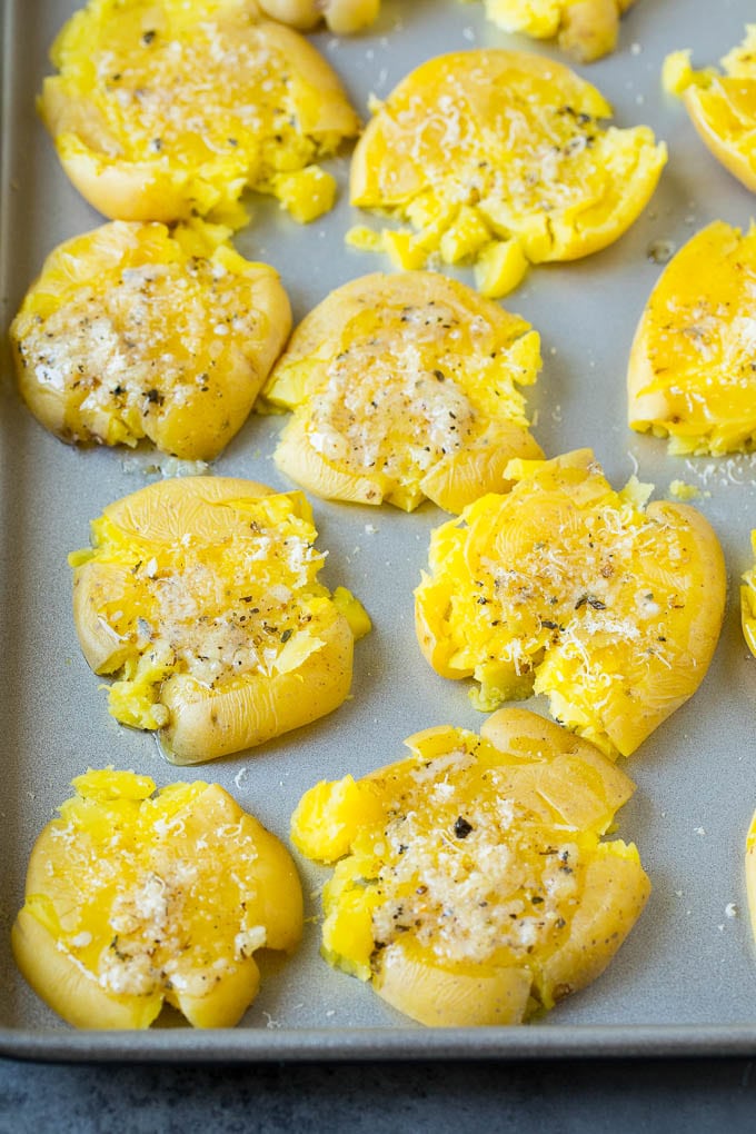 These smashed potatoes are baby potatoes that are boiled until tender, then smashed flat, topped with garlic and herb butter, and roasted until crispy and browned. Flattened potatoes topped with garlic butter, herbs and cheese.