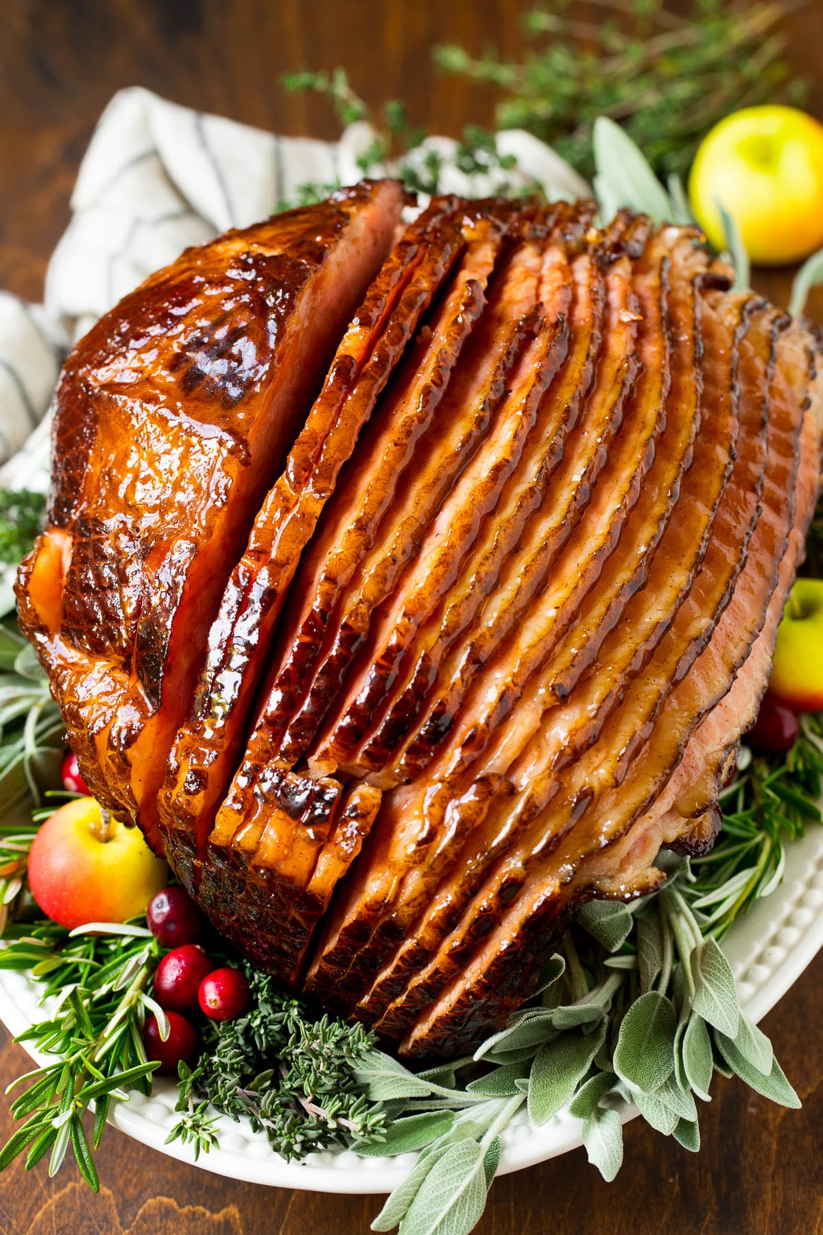 This ham glaze is a combination of butter, brown sugar, pineapple juice and spices, all simmered together until thickened. A ham covered in homemade ham glaze, garnished with fruit.