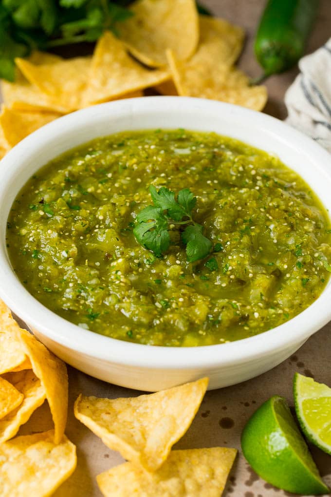 This homemade salsa verde is a combination of roasted chilies, tomatillos, garlic, cilantro and lime juice, all blended together to make a light and refreshing dip. A bowl of salsa verde served with tortilla chips.