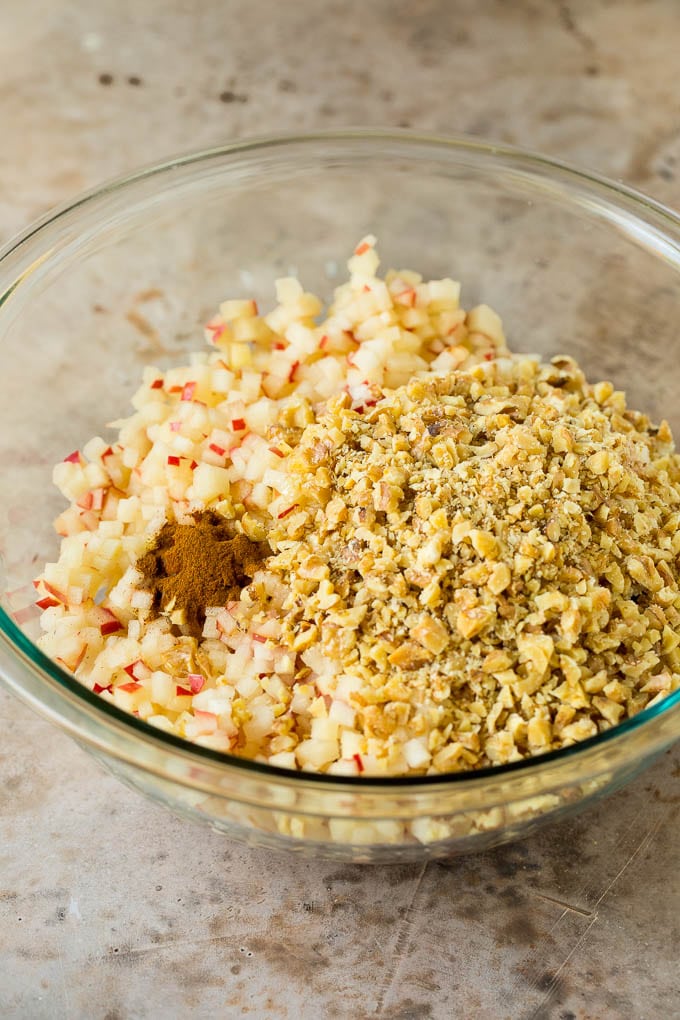 This charoset recipe is a blend of apples, walnuts and honey, all mixed together to make a sweet spread that's an essential part of any Passover meal. Apples, wine, cinnamon and honey all in a bowl.