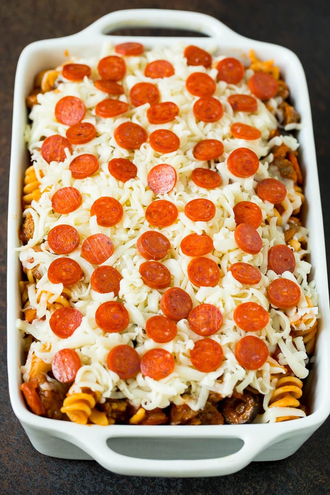 This pizza casserole is pasta simmered in tomato sauce with pepperoni, sausage, olives and bell peppers. Pasta in a casserole dish topped with cheese and pepperoni.