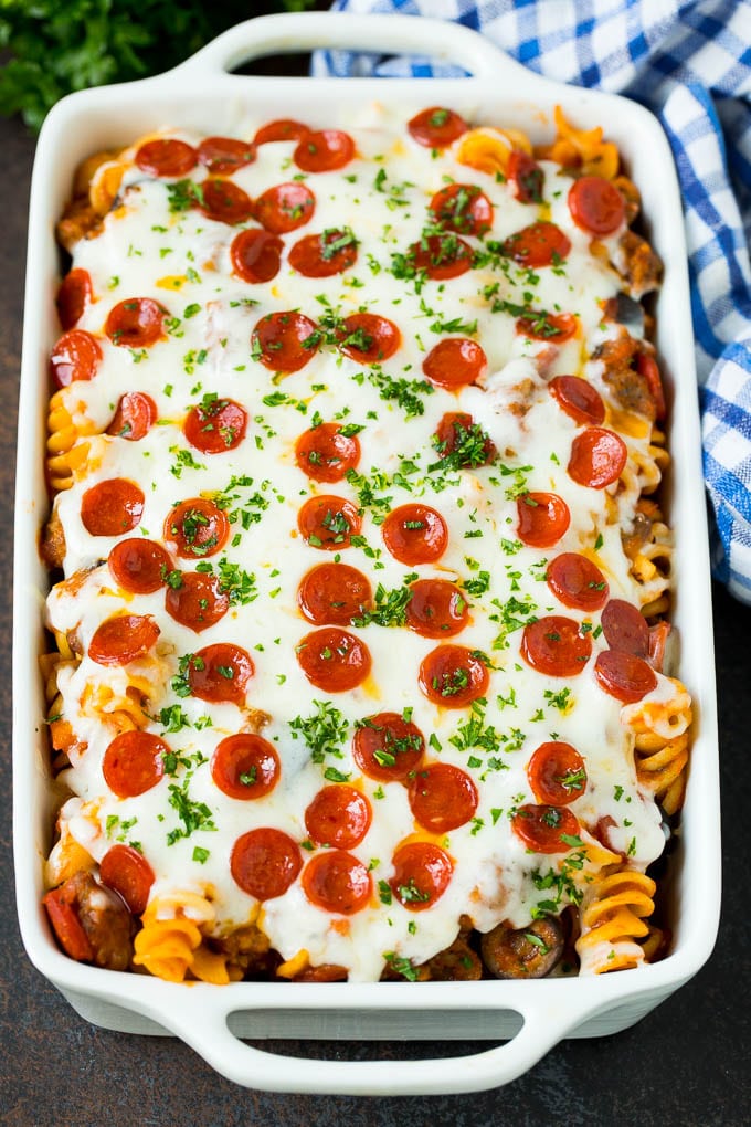 This pizza casserole is pasta simmered in tomato sauce with pepperoni, sausage, olives and bell peppers. Pizza casserole with melted cheese and mini pepperoni on top.