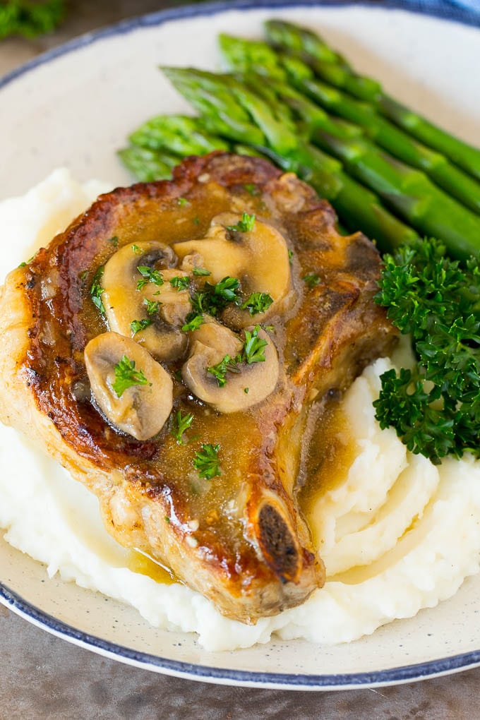 Instant Pot pork chops served over mashed potatoes with asparagus.