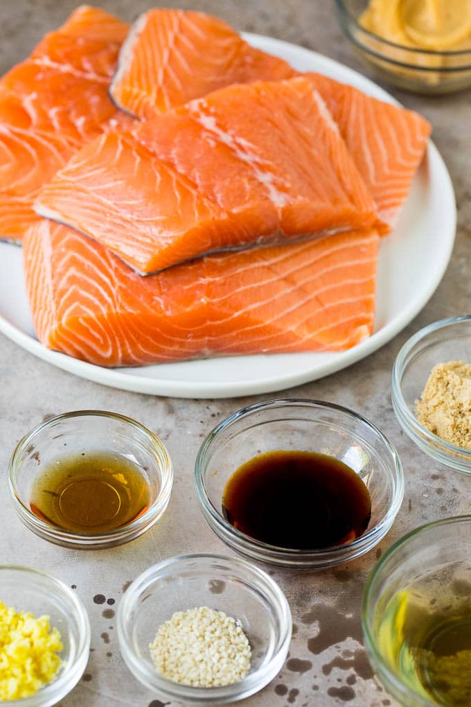 This miso salmon is fresh fish fillets soaked in a flavorful marinade, then broiled to perfection and topped with sesame seeds. Salmon fillets with an assortment of ingredient bowls.