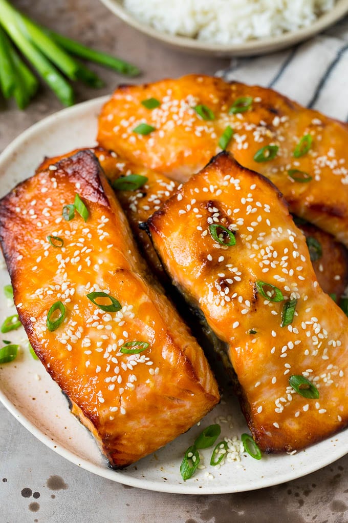 This miso salmon is fresh fish fillets soaked in a flavorful marinade, then broiled to perfection and topped with sesame seeds. A platter of miso salmon fillets topped with sesame seeds and green onions.