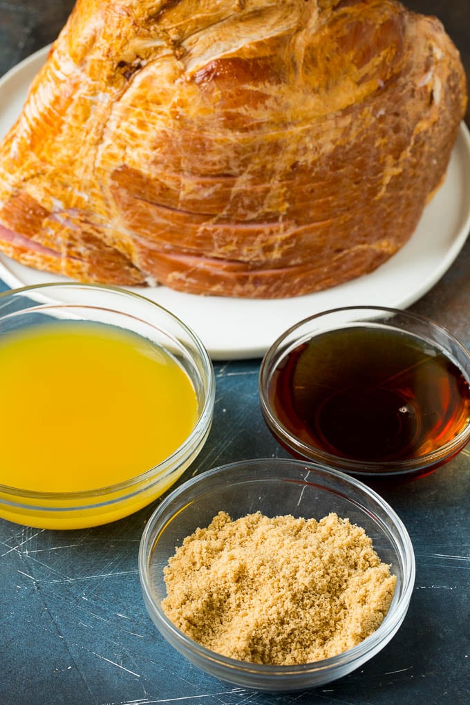 This Instant Pot ham is a spiral ham coated in a 3 ingredient glaze, then pressure cooked to tender perfection. Ingredients including pineapple juice, maple syrup and brown sugar in bowls.