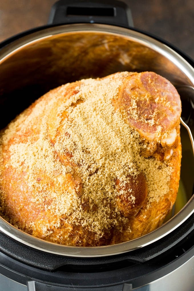 This Instant Pot ham is a spiral ham coated in a 3 ingredient glaze, then pressure cooked to tender perfection. Pork covered in brown sugar in a pressure cooker.