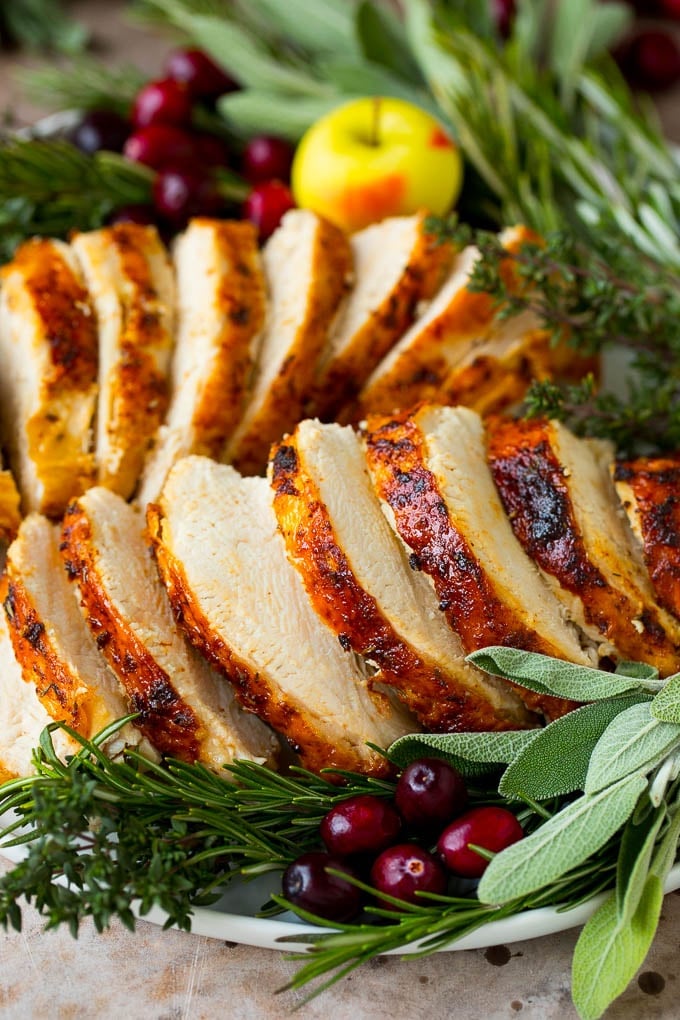 This Instant Pot turkey breast is seasoned with butter, garlic and herbs, then pressure cooked to tender and juicy perfection. Cooked Instant Pot turkey breast sliced and served on a platter.