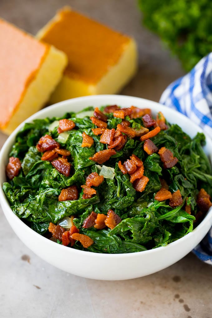 These Southern style mustard greens are cooked with smoky bacon and seasonings until tender and flavorful. A bowl of mustard greens and bacon, served with cornbread.