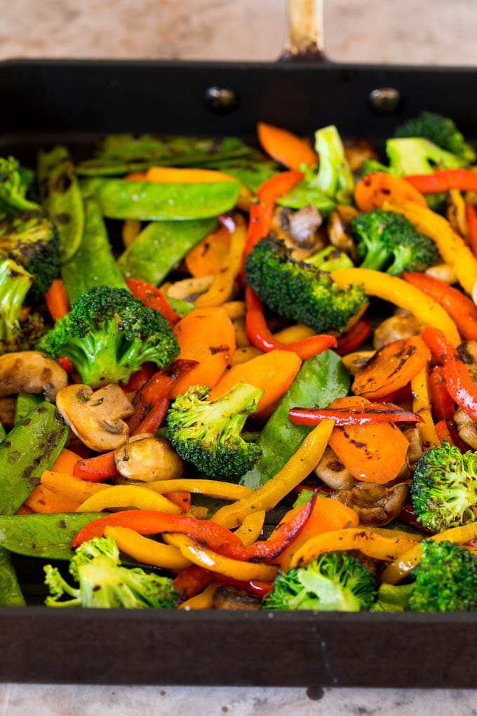 This teriyaki chicken bowl recipe is diced chicken, colorful vegetables and steamed rice served with a homemade teriyaki sauce. Cooked vegetables on a grill pan.