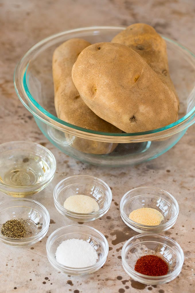 Glass bowls of potatoes, oil and spices.