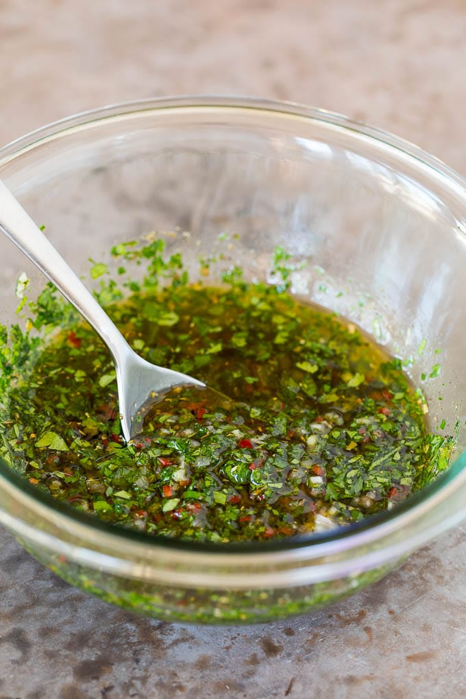 This churrasco recipe is marinated skirt steak that is grilled to tender perfection, then topped with a fresh and flavorful chimichurri sauce. A bowl of homemade chimichurri sauce.