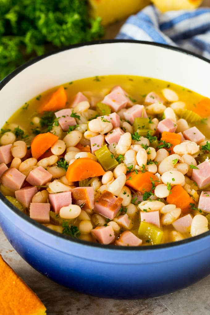 This ham and beans recipe is the best way to use up leftover ham! A pot of ham and beans garnished with parsley.