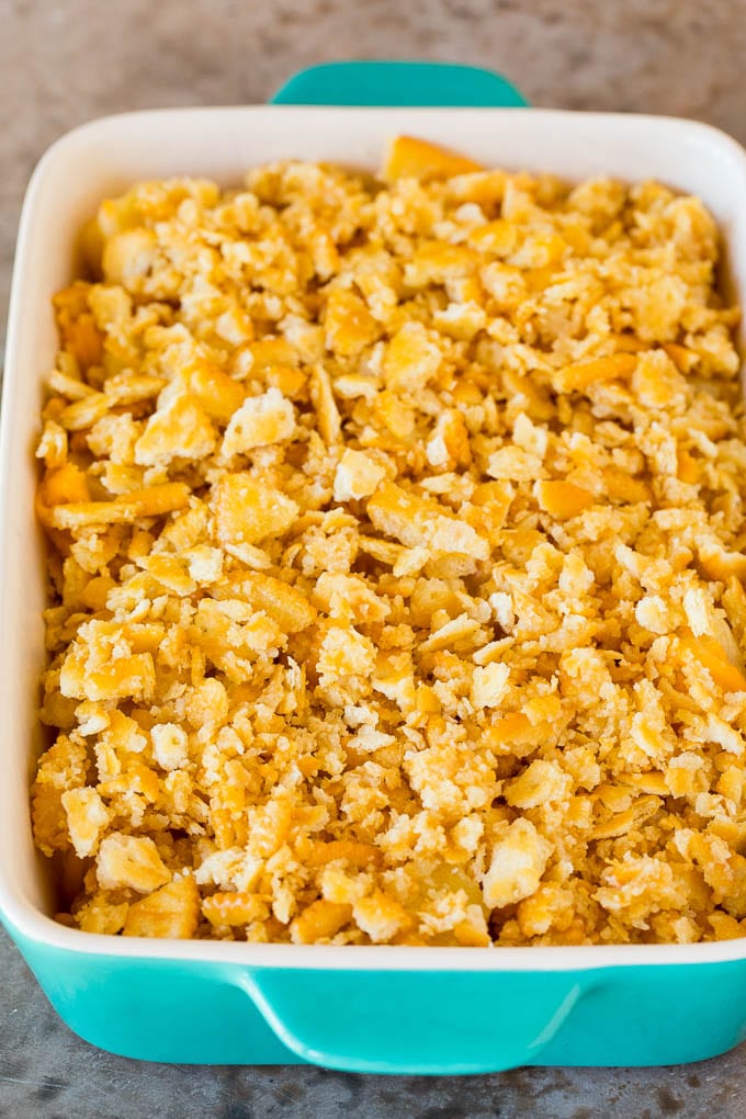 This Southern pineapple casserole is pineapple, cheese and buttery crackers, all baked together to create a sweet and savory side dish. Sweetened pineapple in a casserole dish with a cracker topping.
