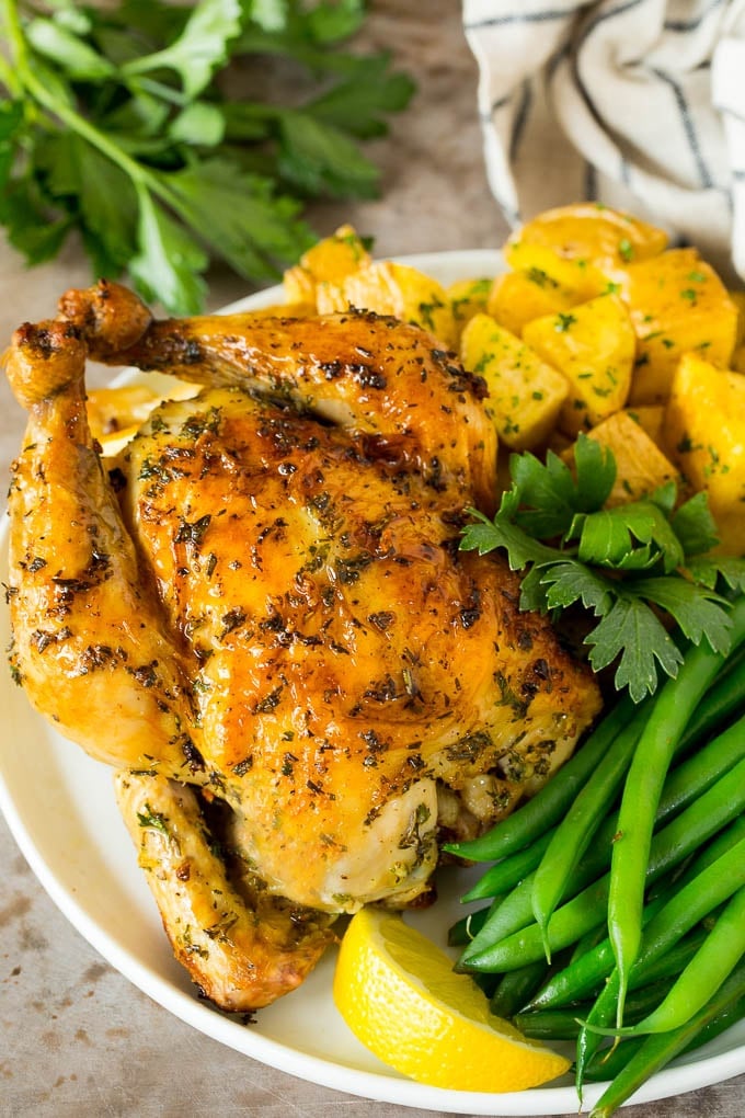 This roasted Cornish hen recipe is an easy and elegant way to make a meal that's quick enough for a busy weeknight, yet fancy enough for a special occasion. Roasted cornish hen on a plate served with potatoes and green beans.