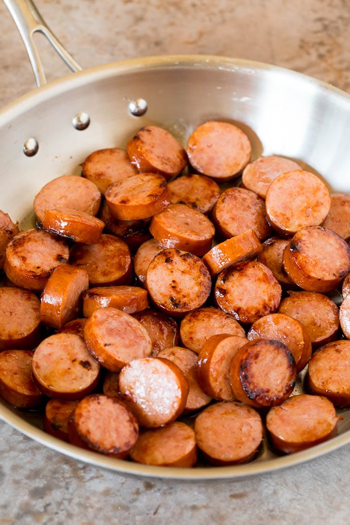 This cabbage and sausage skillet is a combination of smoked sausage, vegetables and savory seasonings, all cooked together to make a quick and easy dinner. Sliced cooked kielbasa in a pan.