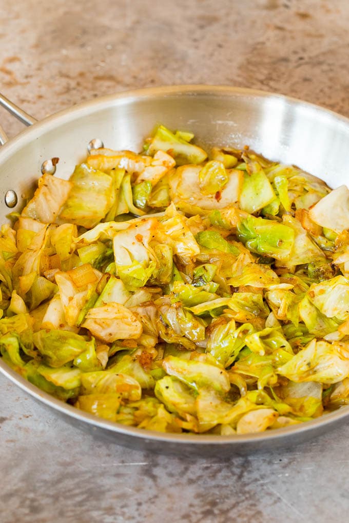 This cabbage and sausage skillet is a combination of smoked sausage, vegetables and savory seasonings, all cooked together to make a quick and easy dinner. Sauteed cabbage with seasonings in a skillet.