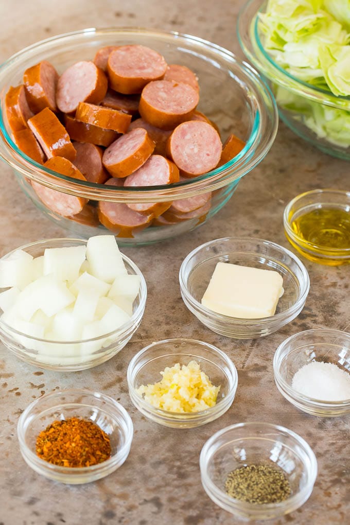 This cabbage and sausage skillet is a combination of smoked sausage, vegetables and savory seasonings, all cooked together to make a quick and easy dinner. Bowls of ingredients for the recipe.