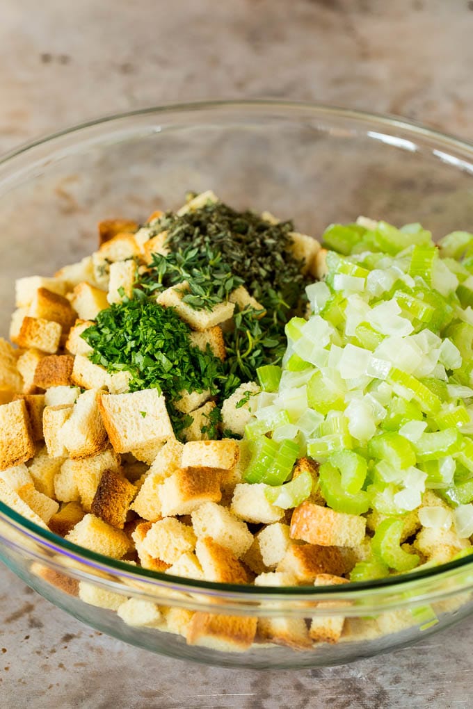 This crock pot stuffing is a mix of bread cubes, sauteed vegetables and seasonings, all placed in the slow cooker to create a flavorful and delicious side dish. A bowl of diced bread, celery, onions, herbs and seasonings.