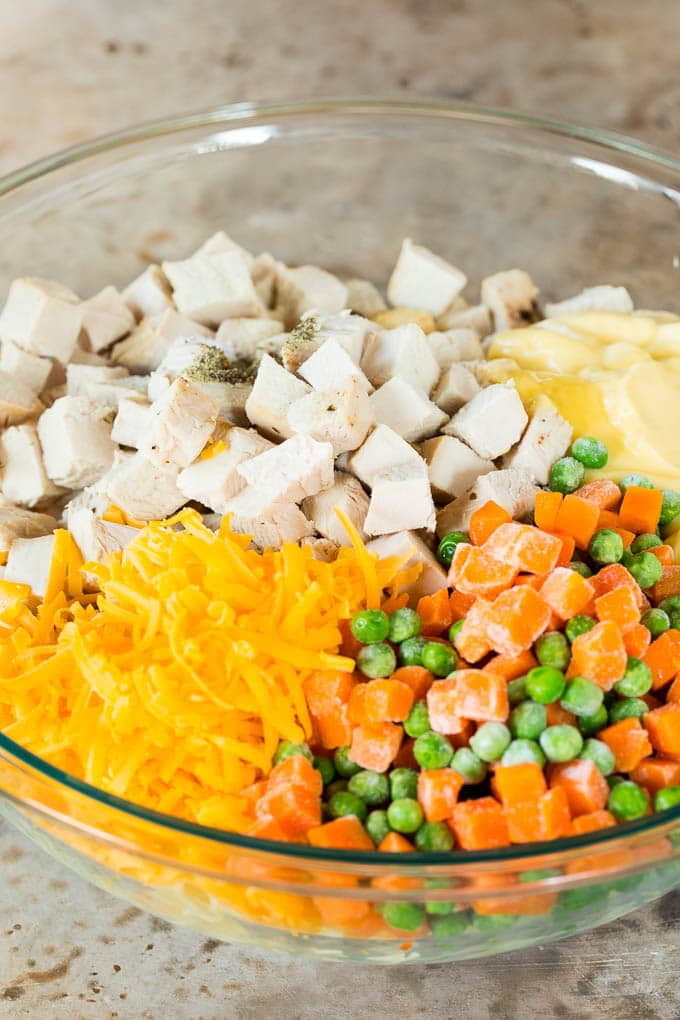 This turkey casserole is made with diced leftover turkey, egg noodles and vegetables, all tossed in a creamy cheesy sauce. Meat, pasta, frozen vegetables and cheese in a large bowl.