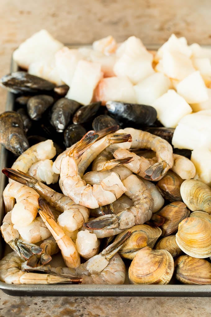 This bouillabaisse is French seafood stew with fresh fish, shrimp, clams and mussels, all simmered together in a flavorful broth. A pan of shrimp, clams, fish and mussels.