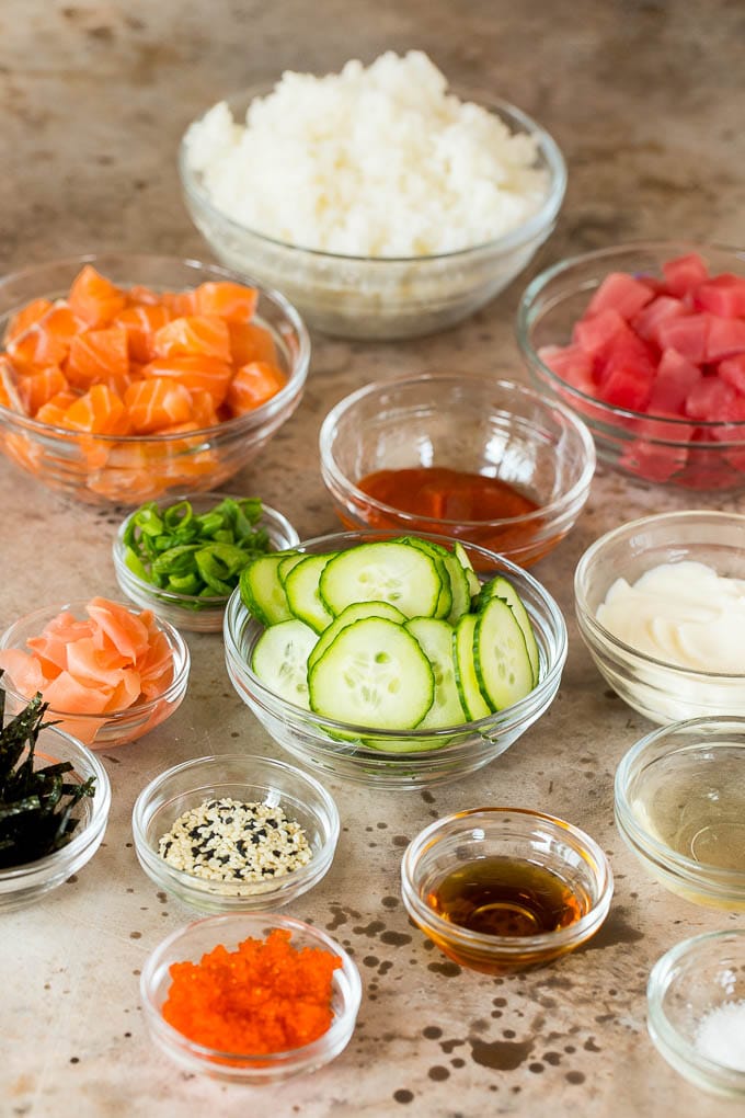 This sushi bowl recipe is assorted fresh fish, avocado, cucumber and seaweed, all served over rice with spicy mayo, picked ginger and tobiko. Bowls of diced fish, cucumbers, rice and seasonings.