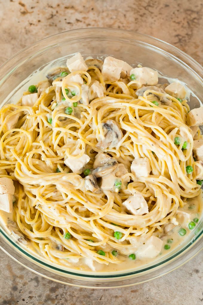 This turkey tetrazzini contains diced turkey, mushrooms and peas, all tossed with pasta in a creamy sauce, then baked to perfection. A mixing bowl of pasta, peas and turkey, all tossed in a creamy sauce.
