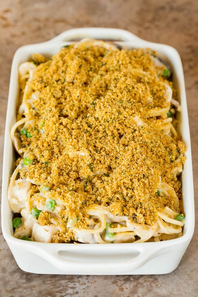 This turkey tetrazzini contains diced turkey, mushrooms and peas, all tossed with pasta in a creamy sauce, then baked to perfection. A casserole dish of creamy spaghetti with breadcrumbs on top.