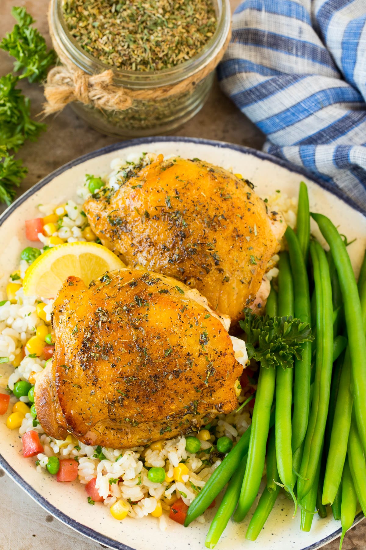 Chicken cooked with Greek seasoning served alongside rice and green beans.